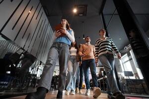Business team in a modern open space startup office walking together. Diverse group of businesspeople smiling while having a discussion. Successful mixed race colleagues collaborating on a new project photo