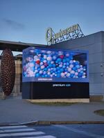 Prague, Czech republic - January 9, 2025 Large format transparent led screen showcasing an animation of colorful balloons at O2 universum Conference center Premium OOH photo