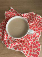 Warm cup of coffee, tea rests on heart patterned napkin, creating cozy and romantic valentine's day breakfast setting photo