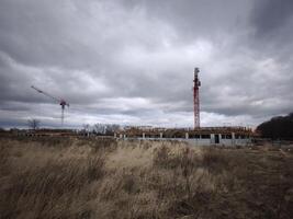 Prague, Czech republic - January 11, 2025 Cranes working on a construction site, building new houses under a cloudy sky Kbely photo