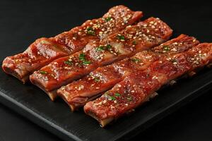 A plate of ribs with sesame seeds on top photo