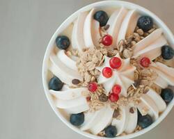 top view of A frozen yogurt swirl with fresh berries and granola toppings photo