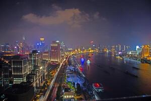 Night view of Shanghai skyline over Huangpu River with colorful reflections c photo