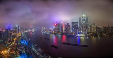 Night view of Shanghai skyline over Huangpu River with colorful reflections b photo