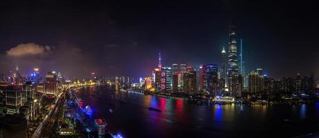 Night view of Shanghai skyline over Huangpu River with colorful reflections f photo