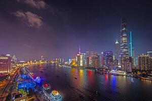 Night view of Shanghai skyline over Huangpu River with colorful reflections d photo