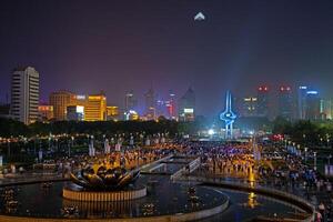 Illuminated fountain show at Quancheng Square in Jinan China with crowds at night b photo