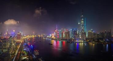Night view of Shanghai skyline over Huangpu River with colorful reflections a photo