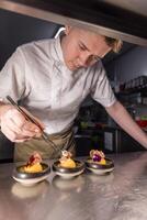 Professional chef carefully placing edible flowers photo