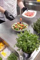 Chef adding smoked salmon in kitchen counter photo