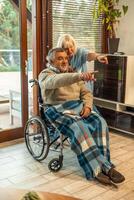 Compassionate Nurse Assisting Elderly Man in Wheelchair pointing photo