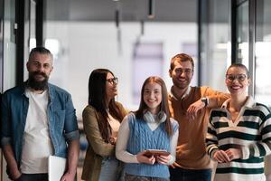 A diverse team of professionals in a modern coworking startup office smiles together, showcasing teamwork, collaboration, and a positive corporate culture that promotes innovation and a dynamic work photo