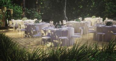 elegante al aire libre evento preparar con redondo mesas en un lozano jardín ajuste video