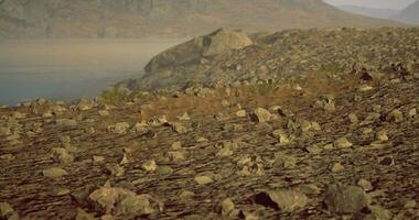 Rocky terrain with distant mountains and clear skies during the day video