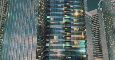 Modern skyscrapers illuminated at night showcasing urban architecture video