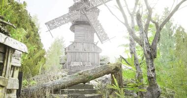 Glimpse of an old windmill surrounded by lush greenery and rustic structures video