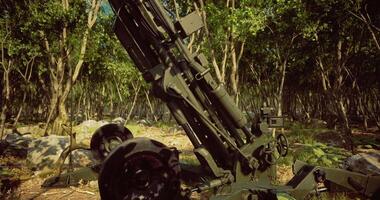 Heavy artillery positioned in a dense forest during a military exercise video