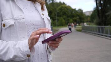 A young adult is engaged in an activity with a mobile device while relishing the tranquil atmosphere of a park photo