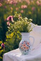 Still life with flowers and a chair in a field of poppies at sunset photo
