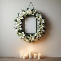 Funeral wreath with an empty center for text or photo, hanging on a plain wall with white candles burning below, creating a solemn atmosphere.22 photo