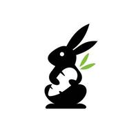 silhouette rabbit logo hugging carrot vector