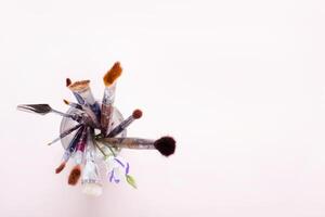 flat lay set of different artistic brushes in glass on table, selective focus photo