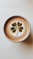 A cup of coffee with a clover leaf on creamy foam, good luck and St. Patrick's Day. photo