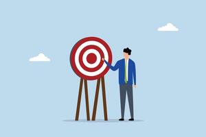 Specific goal, businessman pointing at center of bullseye archery target. vector