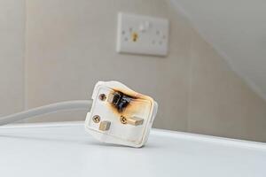 Burned 250V uk style socket and converter. Improper use of AC Power Plugs and Sockets cause of short circuit and fires at home photo
