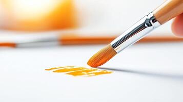 A person holding a paintbrush and a small orange paintbrush photo