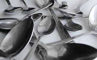 Mix Of Silvery Variety Size Spoons Closeup Angle View. Cutlery Spoons Set Concept Background photo