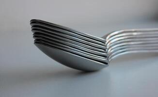 Stuck Of Same Size Silvery Spoons On Clean White Surface. Concept Photo For Table Setting Illustration