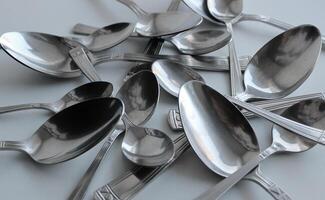 Pattern of spoons of different sizes scattered on a plastic cutting board photo