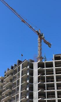 High Altitude Tower Crane Over Concrete Frame Of New Building photo