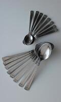Tablespoons And Teaspoons From One Cutlery Set Laid Out In Form Of Wings. Concept Photo For Table Setting Backgrounds