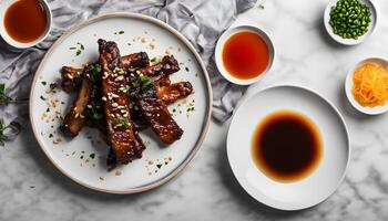 fried sticky ribs marinated in soy sauce and ginger sprinkled on white dish on marble table chinese style view from above photo