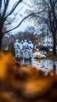 a group of people in protective suits walking through a wet street photo