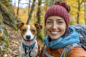 Happy Woman Hiking with Jack Russell Terrier in Autumn Woods photo