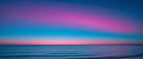 Colorful horizon with neon blue and pink gradient sky over tranquil ocean photo