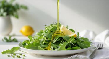 A salad with lemon and greens is being poured over it photo