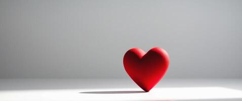 A single red heart rests on a white surface photo