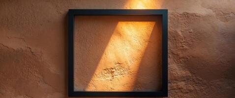 Sunlight shining through black frame on brown wall. photo