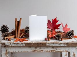 A blank card on a wooden table with autumn leaves and cinnamon photo