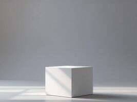 A white cube sitting on a floor in front of a window photo