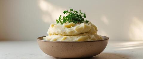 A bowl of mashed potatoes with a sprig of parsley photo