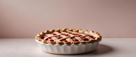 A pie with a lattice top sits in a white bowl photo