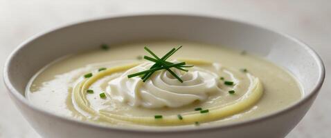 A bowl of soup with a spoon of sour cream photo