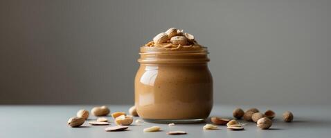 Peanut Butter in Glass Jar with Peanuts and Almonds. photo