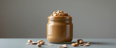 Peanut Butter in Glass Jar with Peanuts and Almonds photo