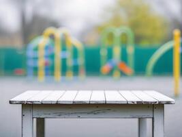 Empty white wooden tabletop on blurred playground backgroundEmpty white wooden tabletop on blurred playground background. photo